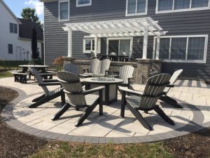 Outdoor living area with firepit and chairs with perangola in back