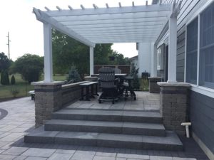Capehart Landscape & Design Back Pation with white pergola and chairs underneath